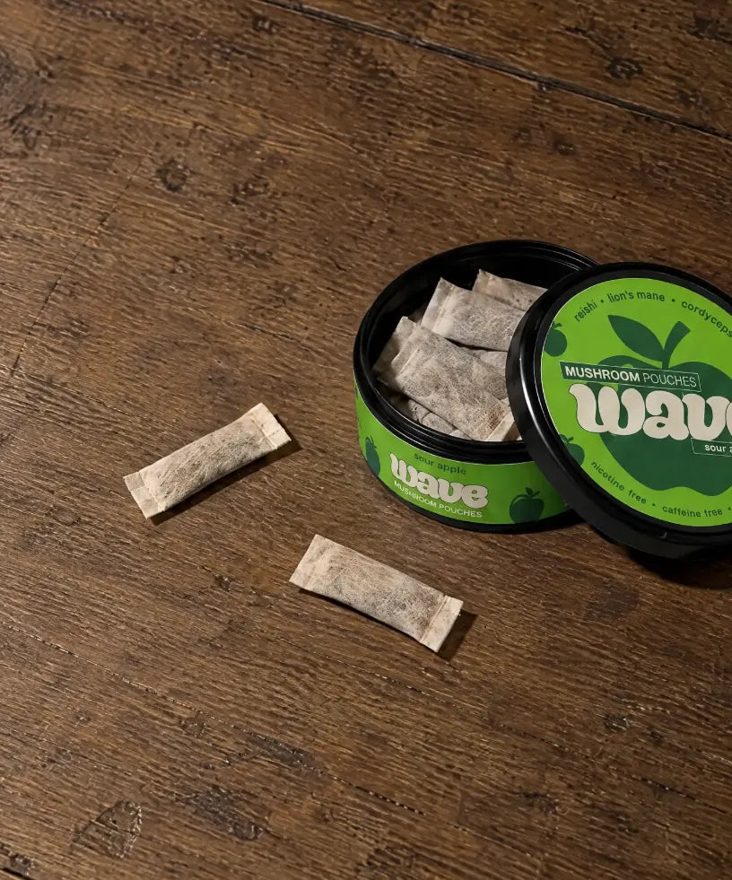 Geopend blikje WAVE-pouches op een houten tafel, met twee pouches ernaast