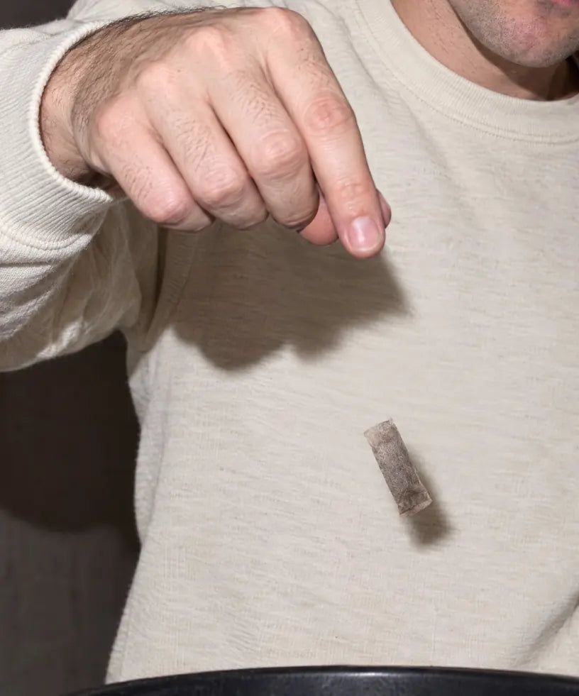 Een gebruikte pouch wordt in een afvalbak gegooid