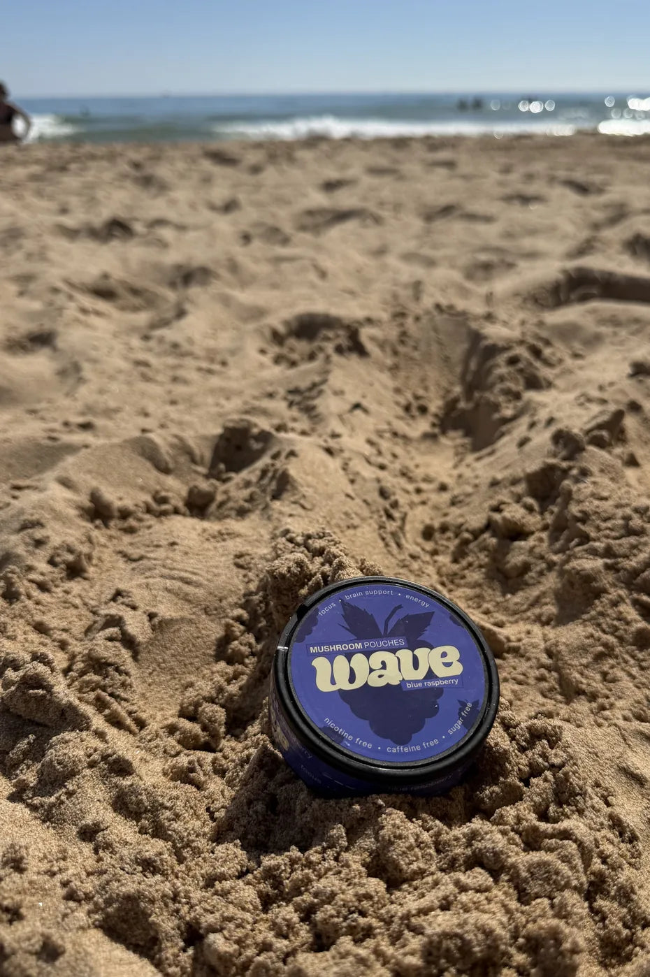 Blikje WAVE in het zand op het strand